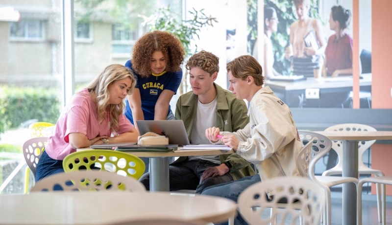 studenten rondom mobieltjes en laptops
