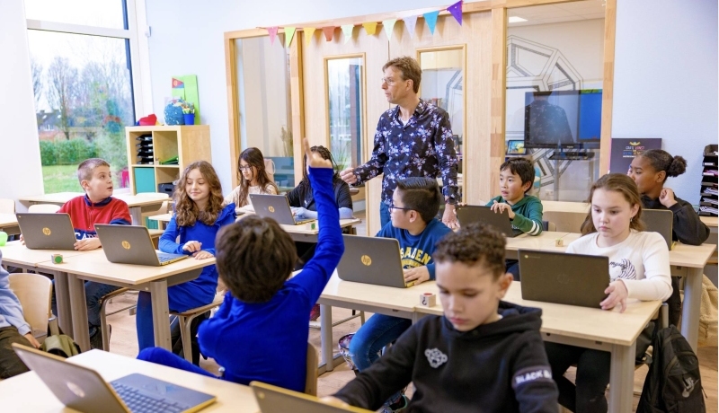 Pabo-docente geeft les aan haar klas en gebruikt daarbij een groot beeldscherm.