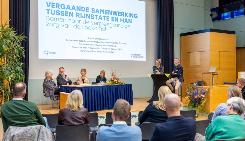 De dagvoorzitters stellen vragen aan het bestuur van de HAN en Rijnstate over de samenwerking.