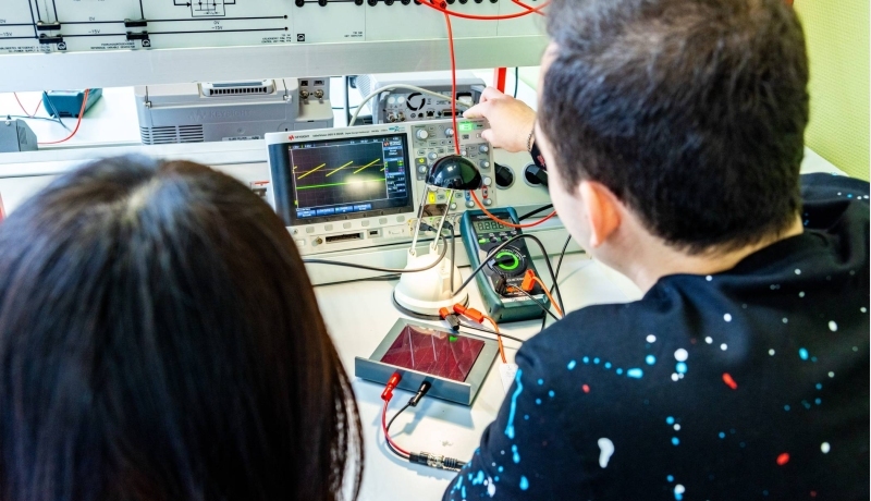 Twee studenten elektrotechniek doen een experiment met een zonnepaneel.