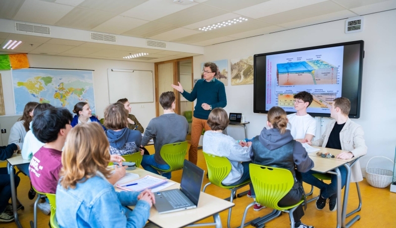 Docent geeft les aan groepje leerlingen in het voortgezet onderwijs