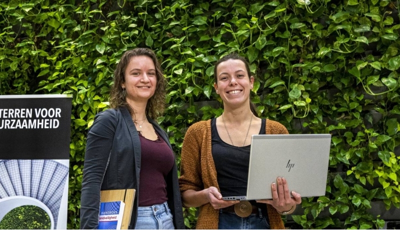 Afstudeerders Fiona Verbrugge (l) en Maaike Diks voor de inpandige groene wand bij HAN Bouwkunde
