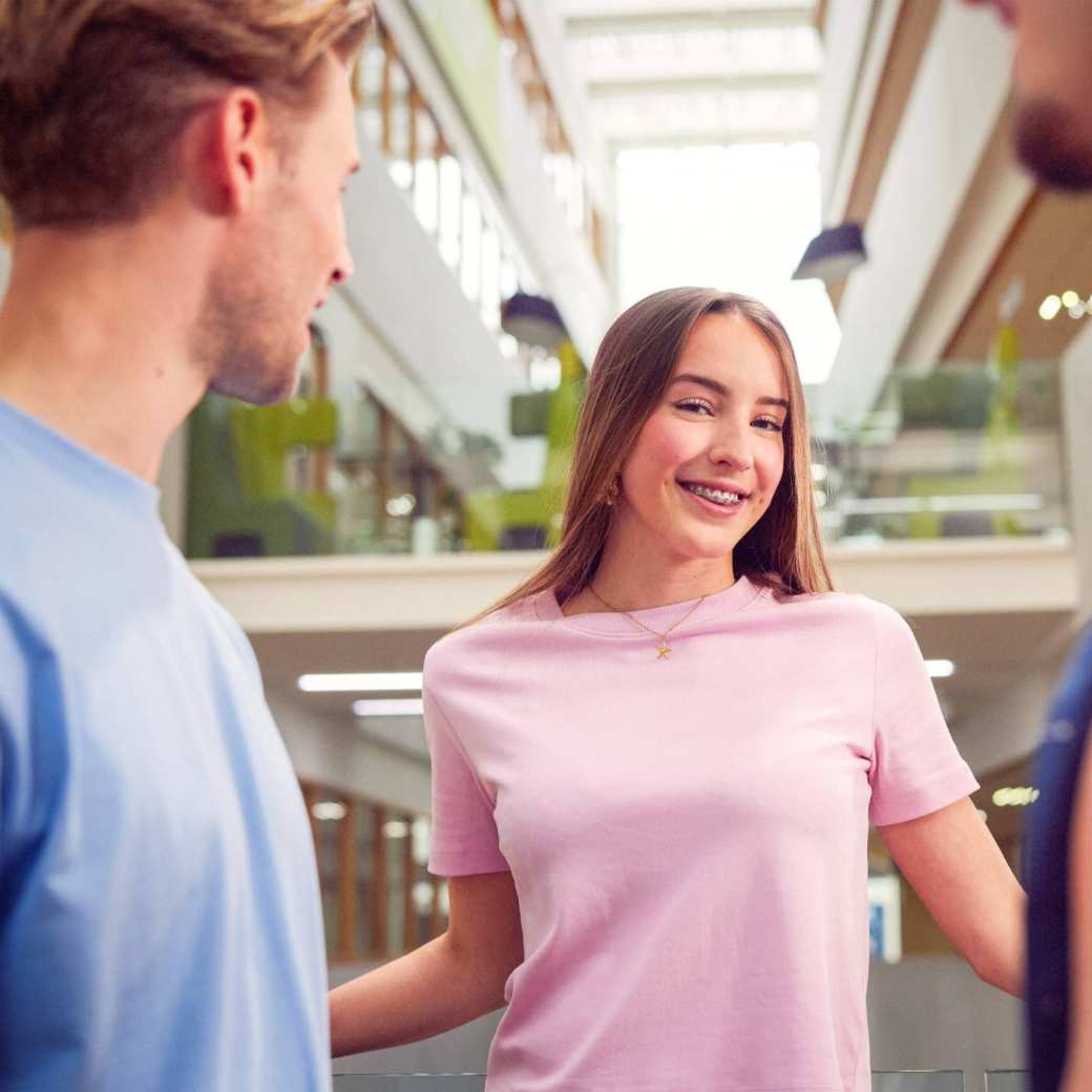 werving voltijd campagne, studente met zachtroze t-shirt bij balustrade