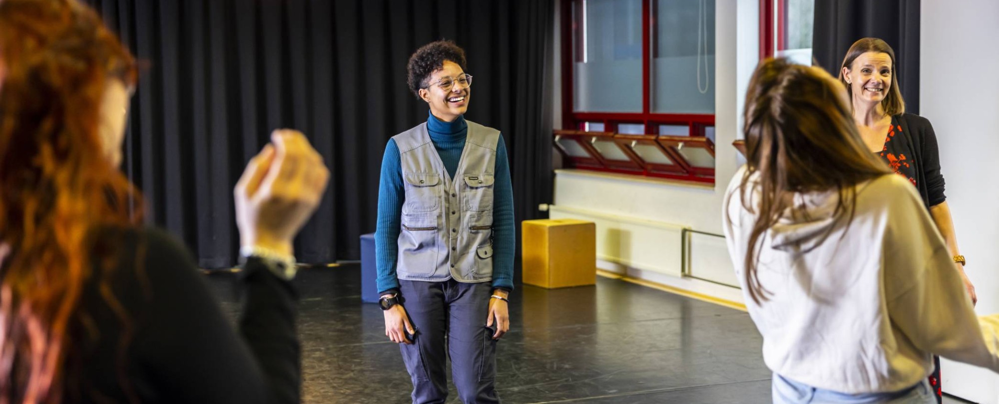 Een vrouwelijke student International Social Work lacht. Ze is bezig met het creatieve vak Drama.