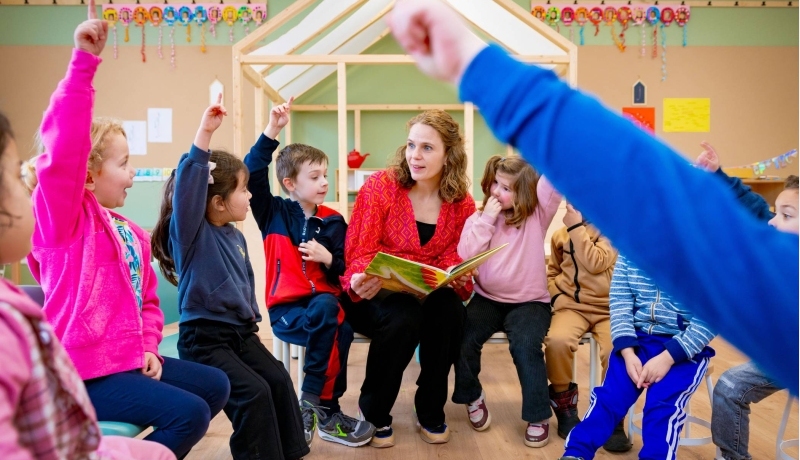 Juf en kleuters spelen samen