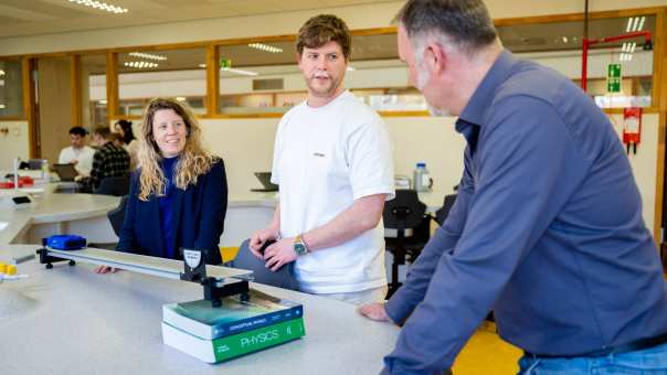 Docent en student bezig met natuurkunde proef