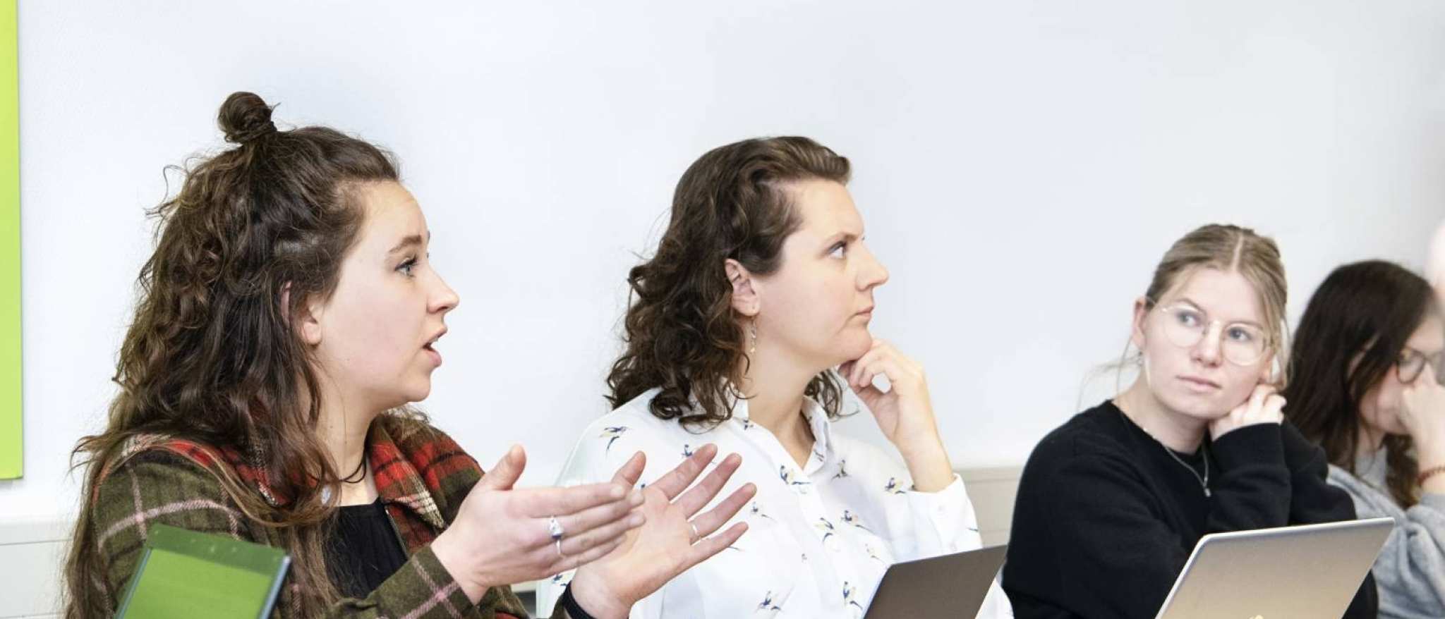 Studenten tijdens lessituatie, 1 student legt uit. 