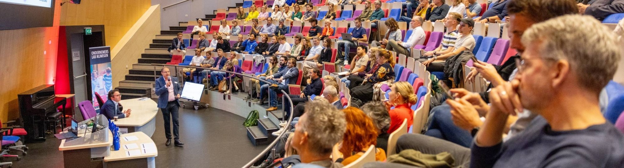 Een groep deelnemers van de Masterclass AI van het Business Service Center luisteren naar het plenaire deel