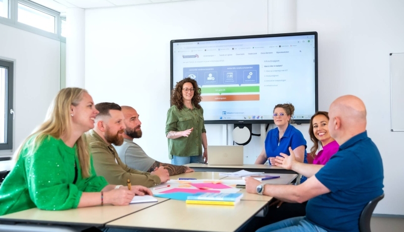 groep studenten van de opleiding Learning & Development in een klaslokaal. Eén student presenteert iets, de rest luistert
