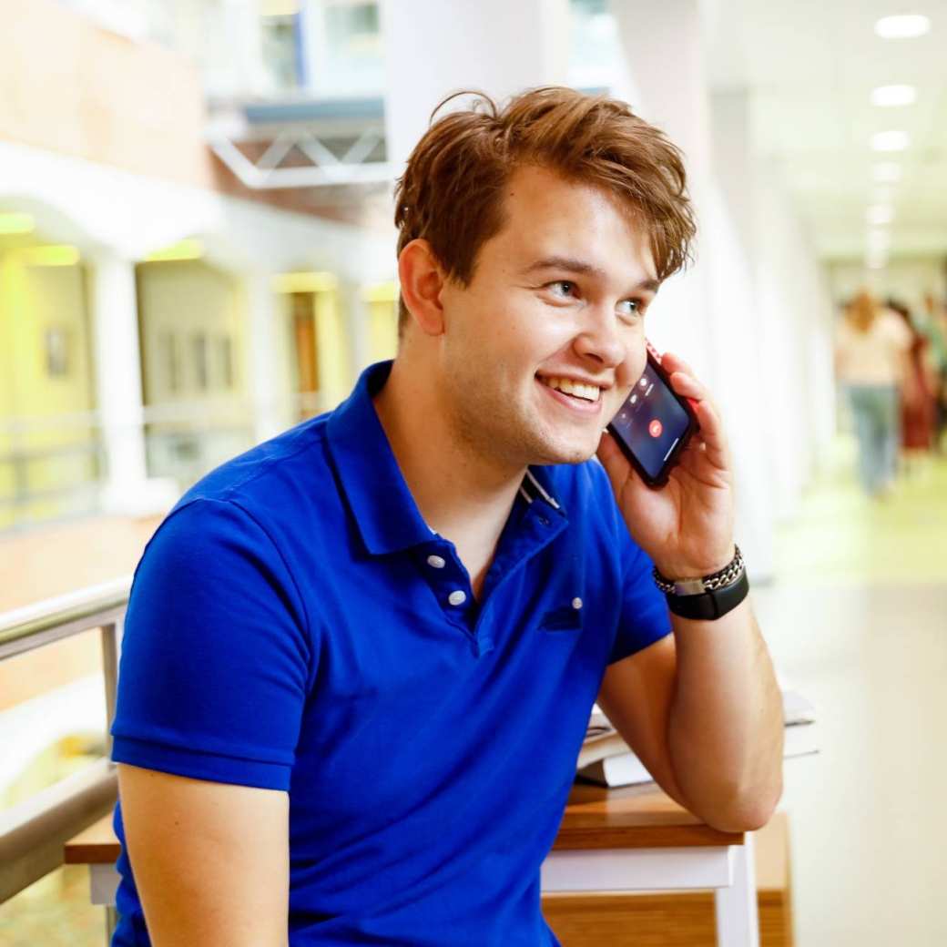 man bellen telefonisch overleg student hal gang