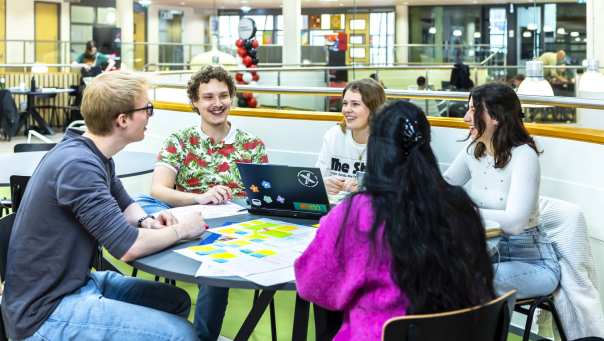 Groep studenten samen aan het werk met ICT project