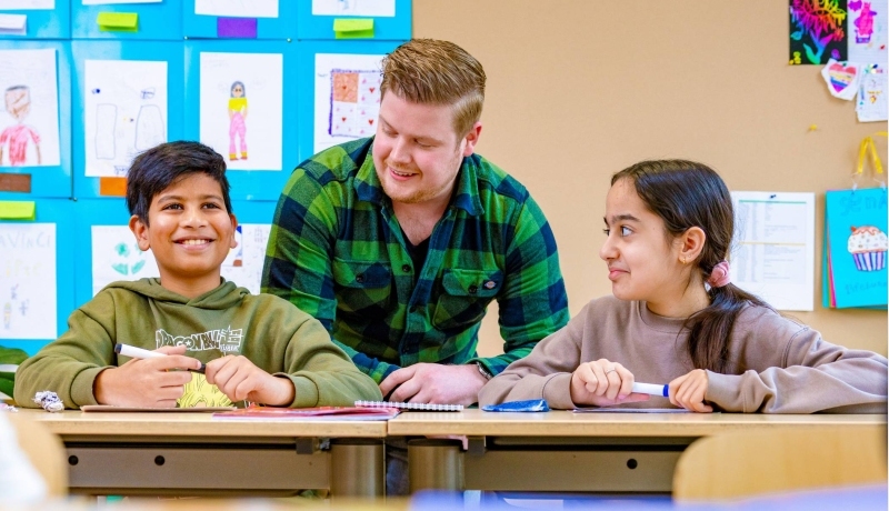 Groep 5,6,7 op de school Da Vince. De leraar zit tussen twee leerlingen in. 