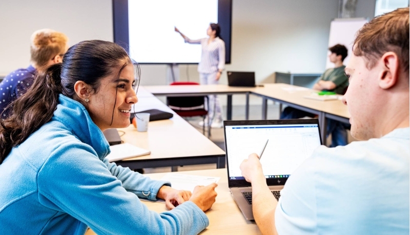 Studenten overleggen in de klas om een wiskundige berekening te maken