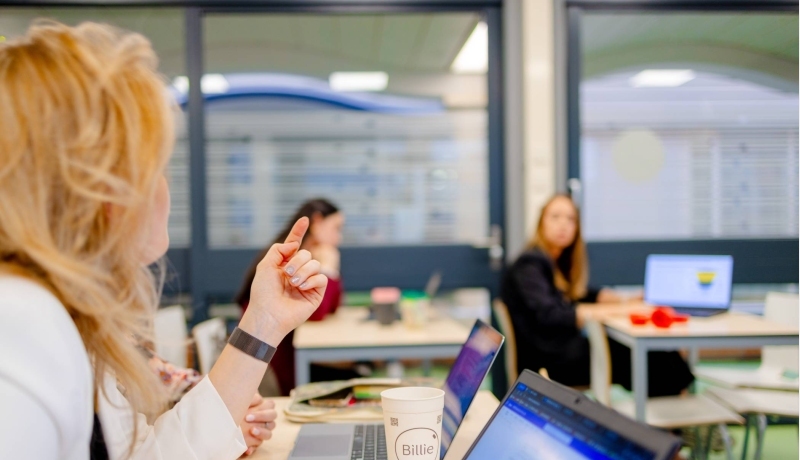 HAN duaal studenten met elkaar in discussie tijdens college.