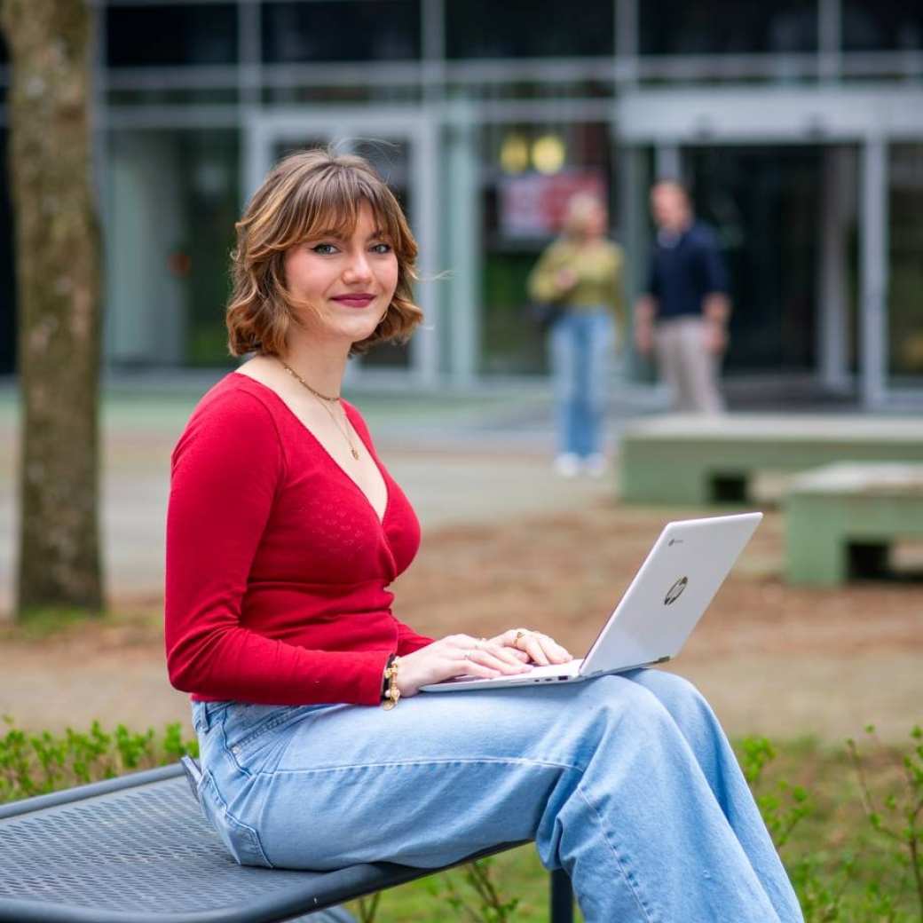 student learning and development buiten met een laptop bij de HAN campus Nijmegen