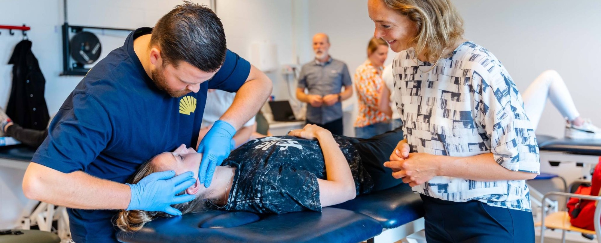 Fysiotherapeut draait hoofd van patiënt op behandeltafel