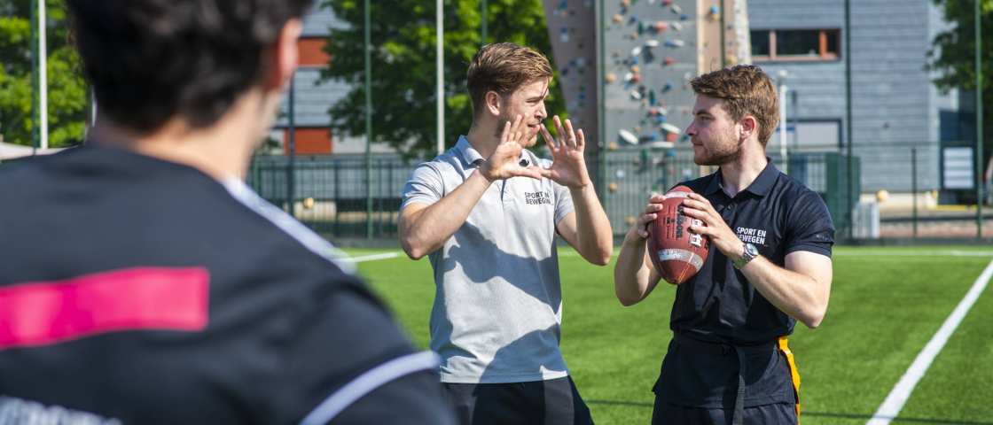 docent geeft les op sportveld