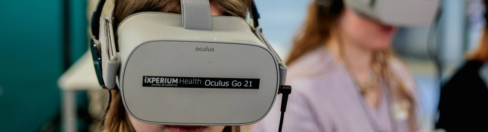 Twee vrouwen met een grijze virutal reality bril op van ixperium health