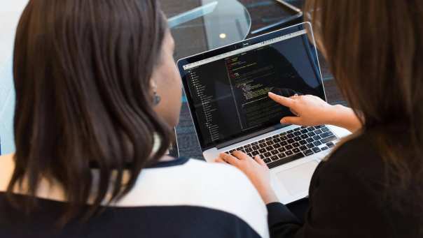 twee personen kijken op een laptop