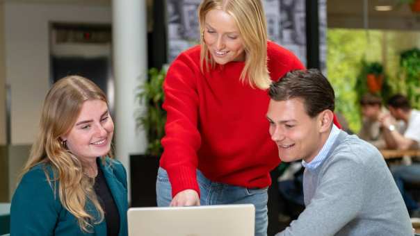 Student hbo Facility Management laat iets zien op de laptop aan andere studenten