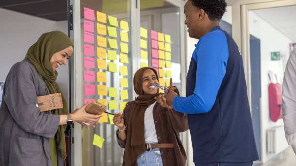 Health fotoshoot wijkcentrum studenten staan met docent bij plakbriefjes