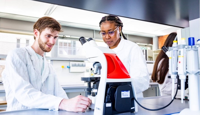 twee studenten in het lab met microscopen