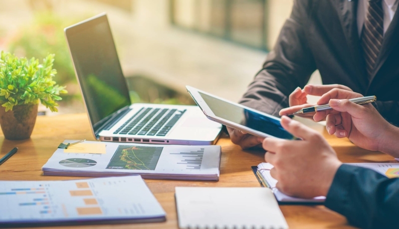 Stockfoto met laptop, papieren en financiën voor publicatie van het associate lectoraat Sustainable Finance & Tax van AFEM.