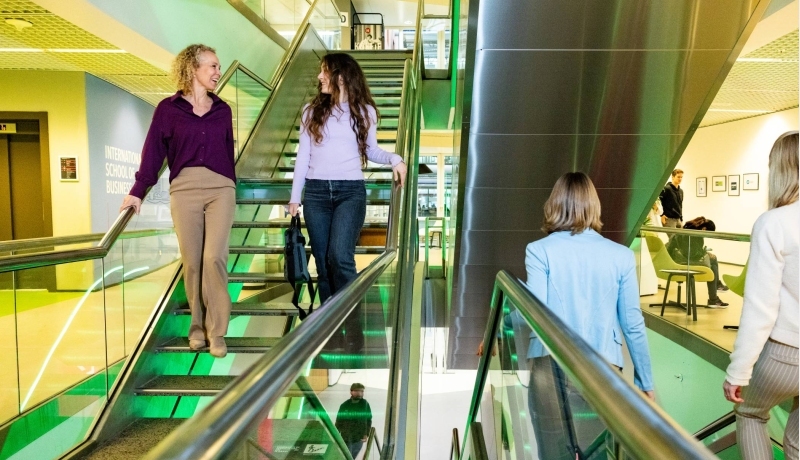 twee studenten Strategisch HRM praten in de gang van de HAN-campus