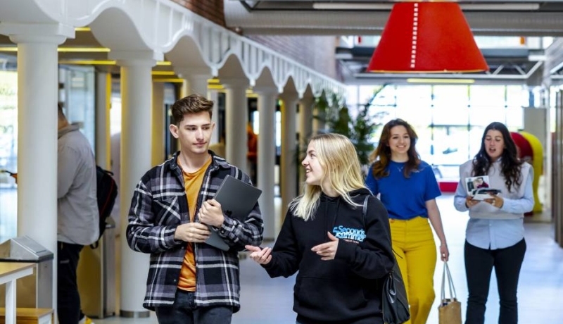 HAN studenten van de Engelstalige Communication opleiding lopen door een gang