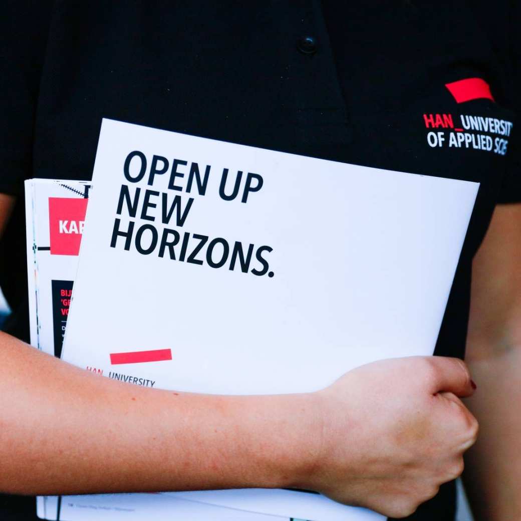 Student houdt flyers onder de arm tijdens de open dag HAN