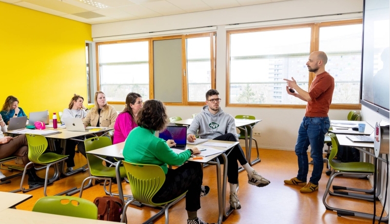 De studenten kijken naar de leraar die hun les geeft in het klaslokaal.