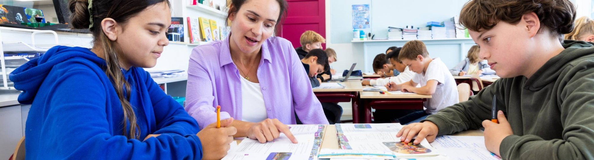 Docent Leonie van de opleiding leraar basisonderwijs aan tafel met leerlingen