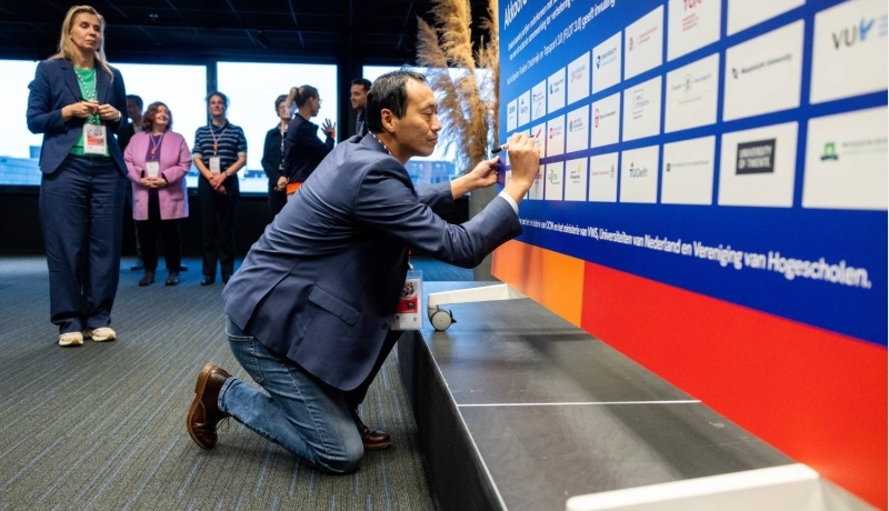 Yihuan Chang, academiedirecteur van Sport en Bewegen, tekent het akkoord