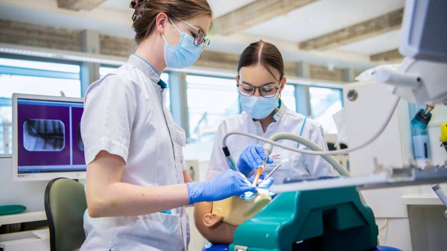 2 studenten voeren een behandeling uit op een patient.