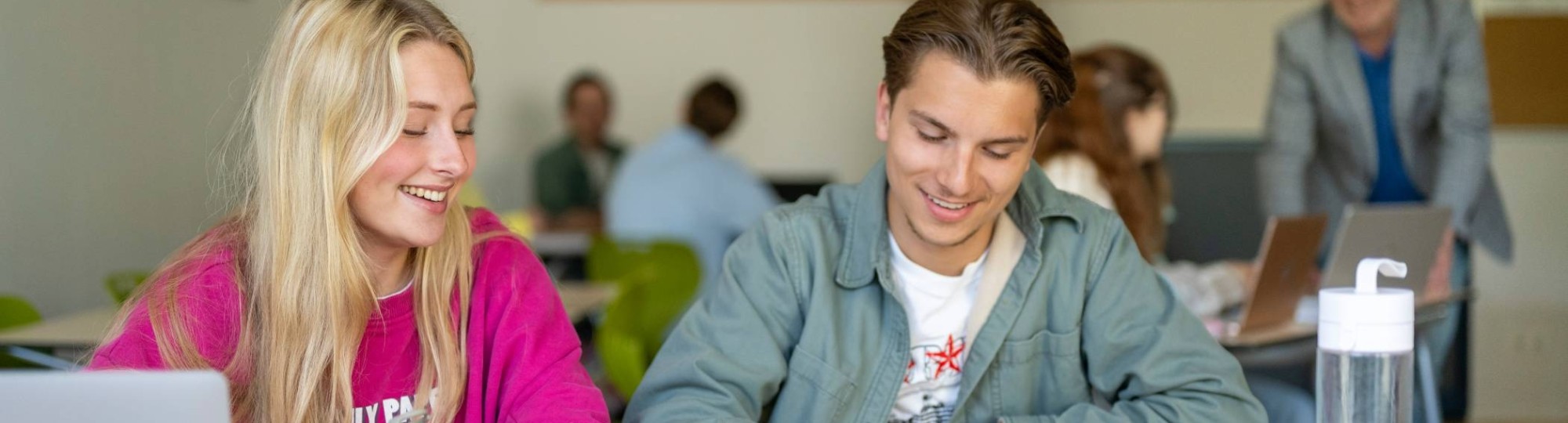 Twee studenten werken samen en hebben plezier. 