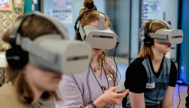Drie vrouwen met een grijze virtual reality bril op