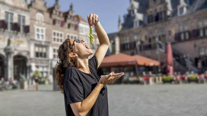 Vrouw eet een krekel alsof het een haring is