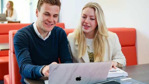 2 cursisten Business Intelligence werken samen achter een laptop.