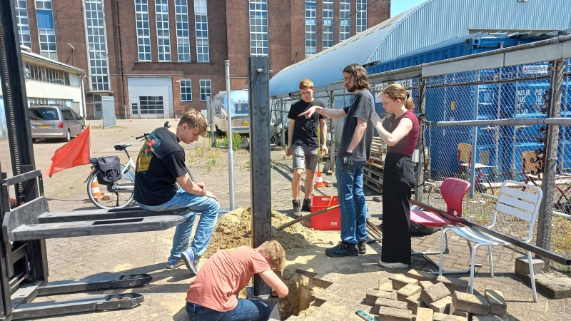 Studenten werken aan plaatsing van de fundering