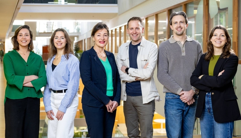 Patiënt op loopband en revalidatiearts kijkt mee naar een scherm om te volgen
