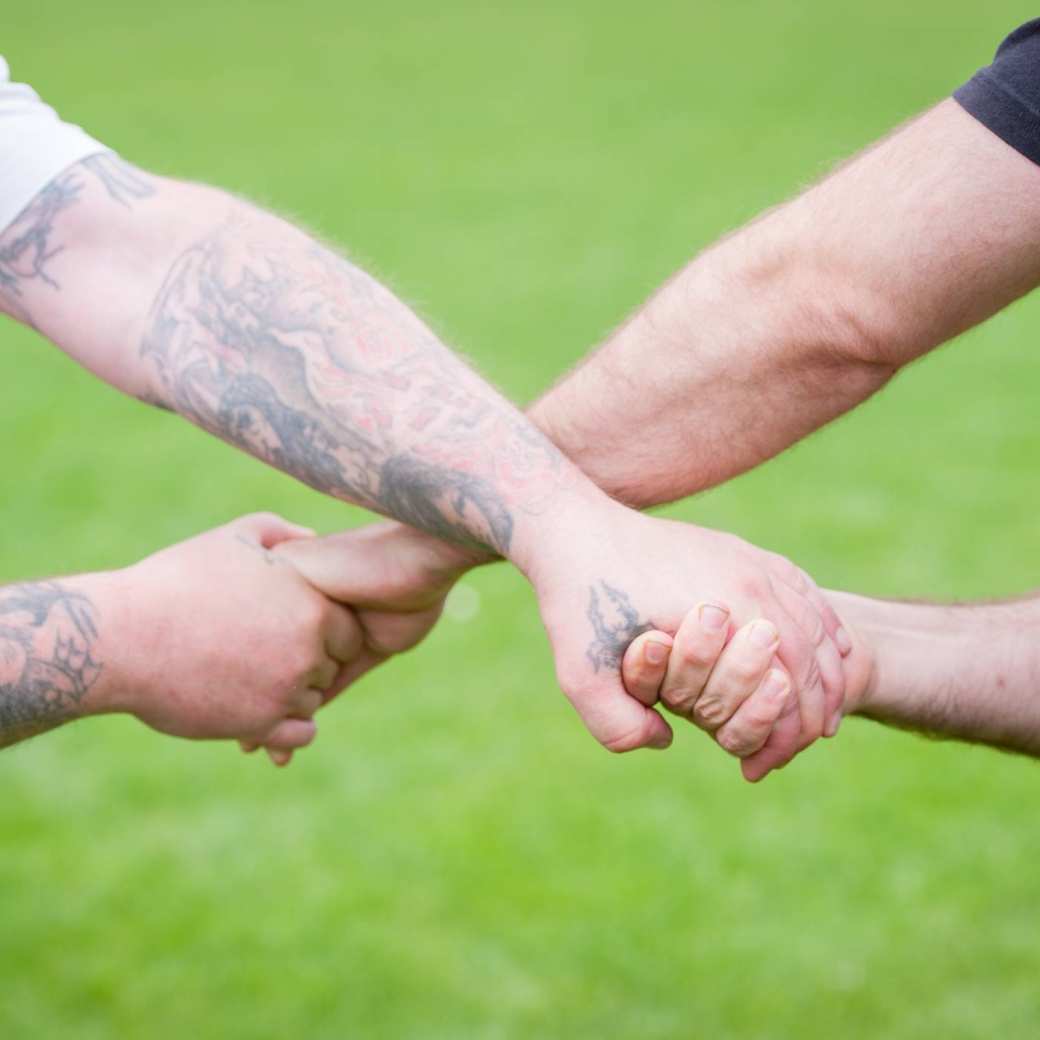twee personen die kruislings elkaars handen vasthouden als een vorm van samenwerking