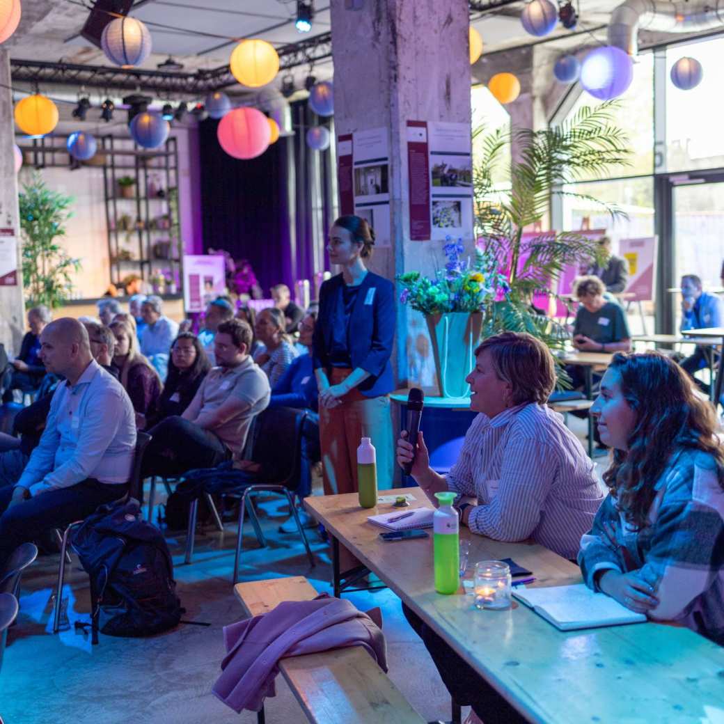 Symposium Nieuwe Wonen 2023. Mensen luisteren naar sprekers.