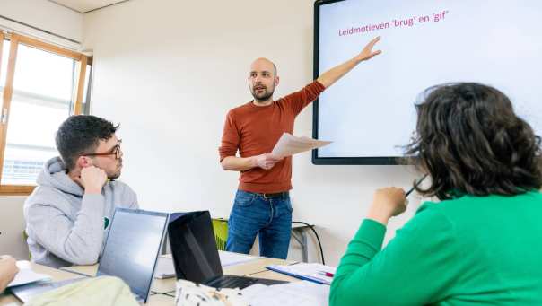 Leraar Nederlands staat voor de klas voor een whiteboard.