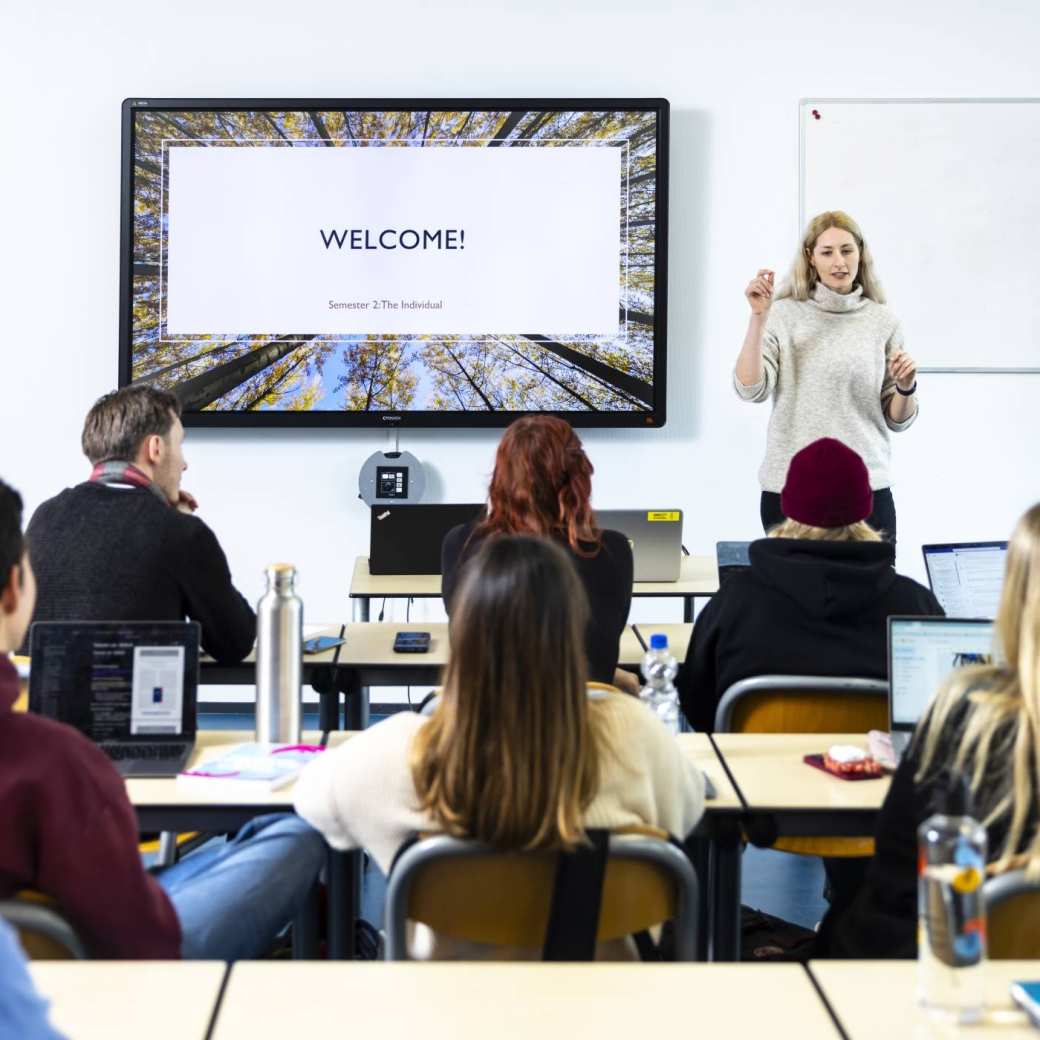 International Social Work. Klas college groep studenten en docent. digiboard op de achtergrond