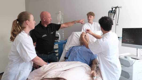 Studenten ambulance met simulatiepatiënt op brancard