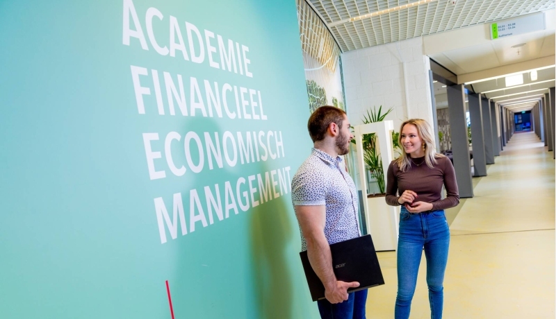 2 HAN studenten Finance, Tax and Advice voor de gang met lokalen op de leslocatie in Arnhem