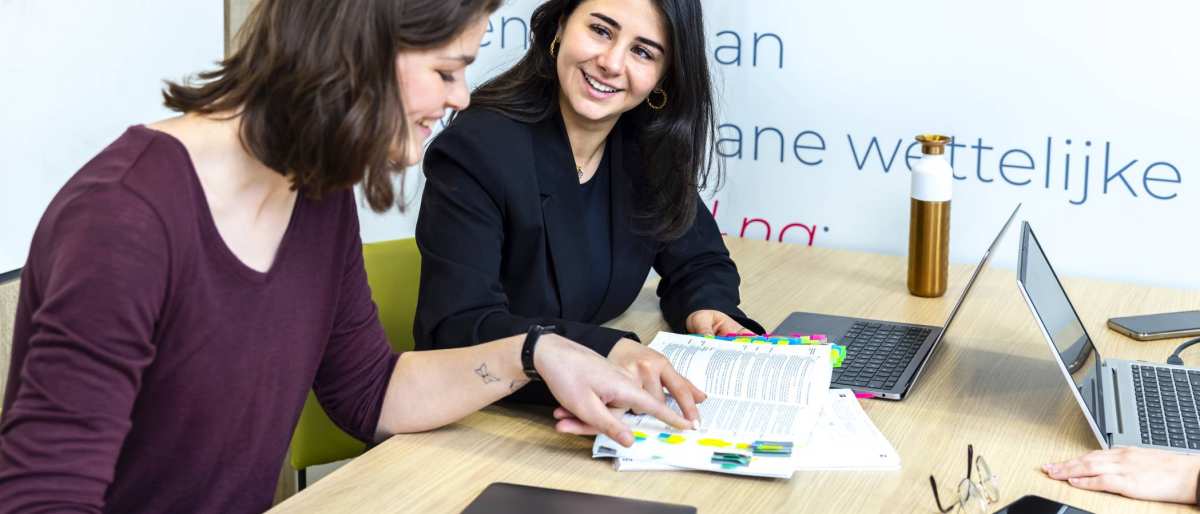 Studenten wijzen iets aan in de wettenbundel 