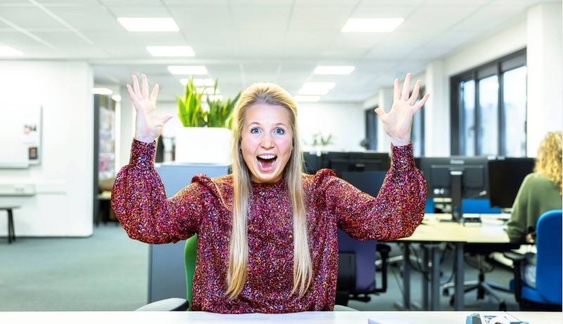 Juichende dame blond achter computer in kantoor