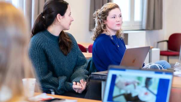 Twee vrouwelijke studenten overleggen in de les