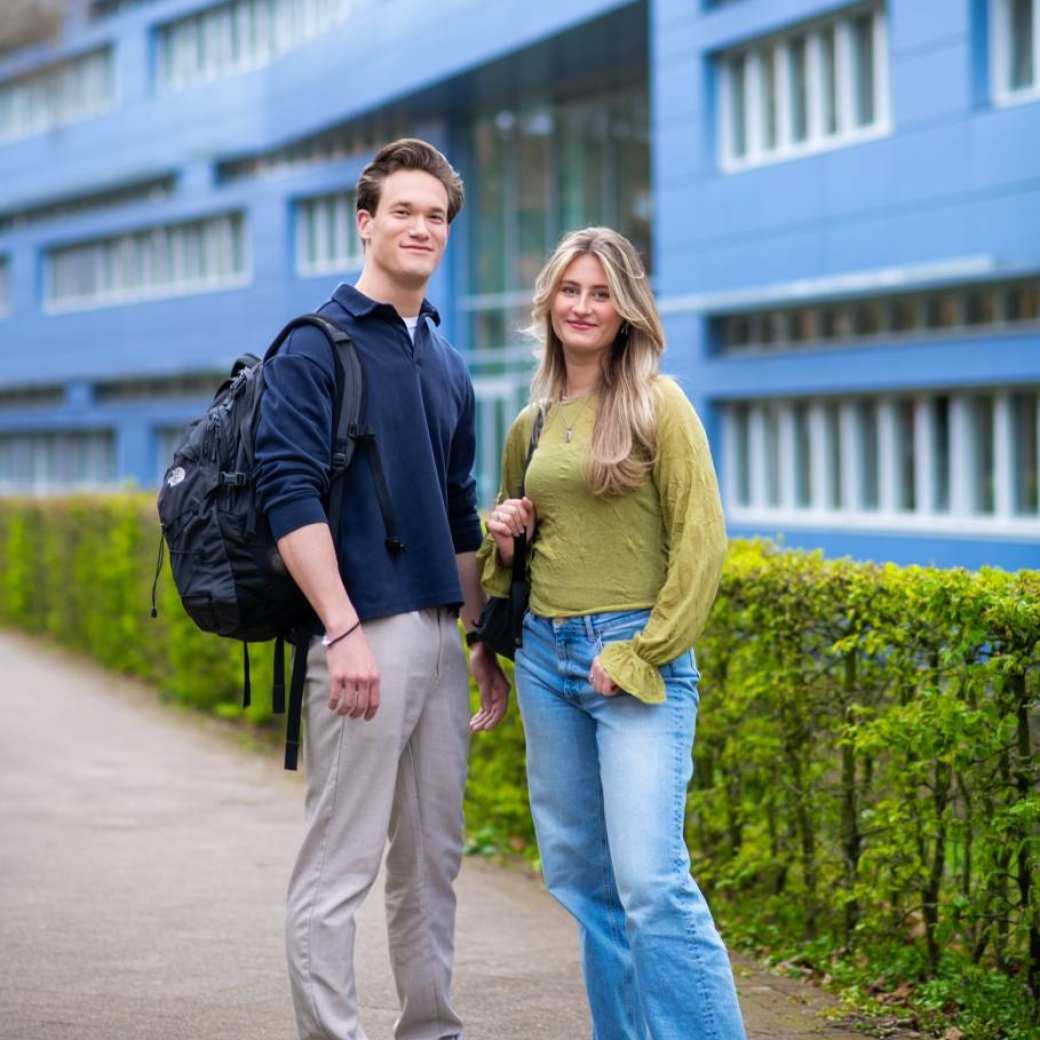 Twee studenten van Learning and Development in Organisations voltijd kijkend in de camera voor Laan van Scheut 10 in Nijmegen.